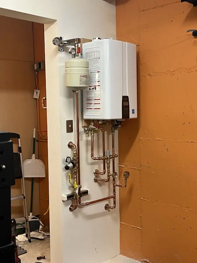 Plumbing technician inspecting water heater connections in Fairfield